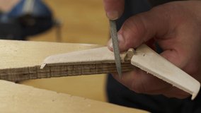 master polishes wooden plane model horizontal stabilizer planes with file and wipes sawdust with brush slow motion closeup - Powered by Shutterstock - Get 15% off with code: PIKWIZARD15