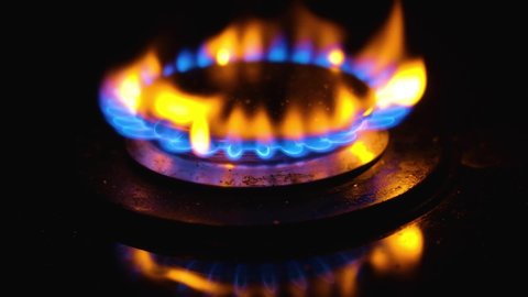 Blue flame of gas stove on black background. Kitchen burner turning on. Natural gas inflammation. chemical reaction. Staining the flame in yellow-red color when sprinkled with salt. Slow motion