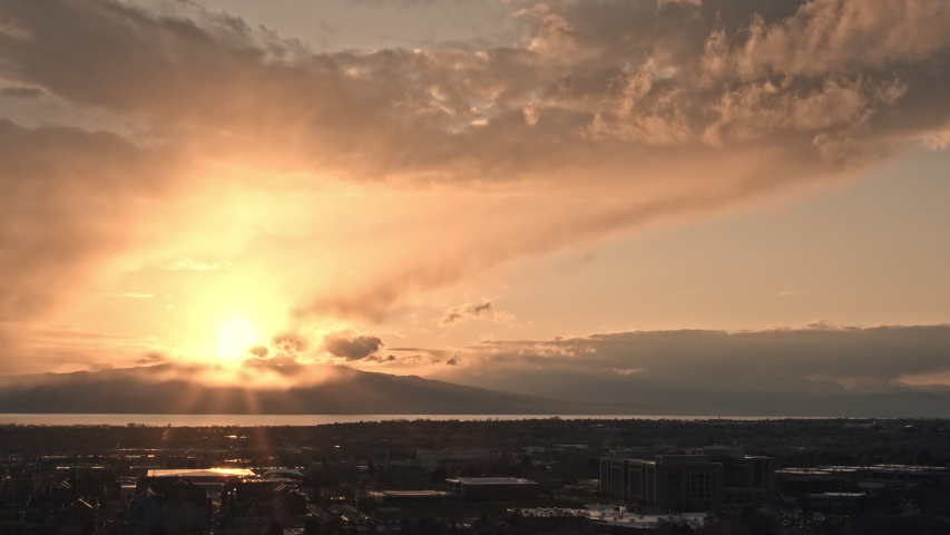 Sunset time lapse as light rain falls from the sky over Provo as the clouds light up in vibrant colors.