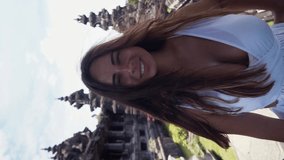 Close up portrait of a tourist woman background Bajra Sandhi Monument in Bali. Travel Concept. Vertical video