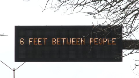 Road sign close up reading "Keep your distace, 6 feet between people" as the corona virus sweeps across the country.