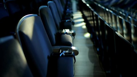 Quarantine due to coronavirus pandemia. Empty theater auditorium or cinema with dark blue or black seats. Modern cinema auditorium with 3d glasses and many rows of seats. Dark movie theatre.
