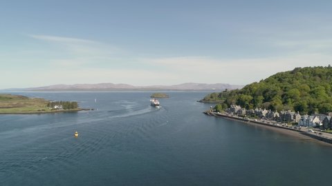 Aerial shot revealing the sea entrance to Oban with Ferry departing towards Mull