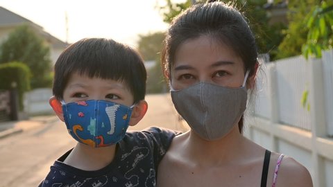 slow motion, asian child boy and mother wearing fabric mask protect disease virus covid-19 epidemic in outdoor : vidéo de stock