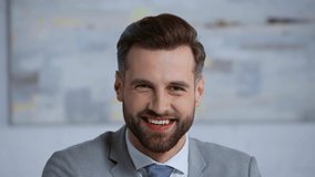 happy and bearded businessman smiling in office