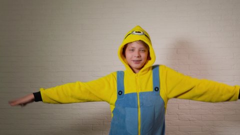 Chernihiv, Ukraine - January 16, 2020: Closeup view video portrait of cute happy funny kid dressed in blue and yellow minion costume dancing cheerfully.