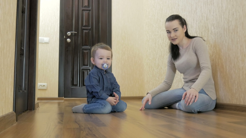 Toddler playing with mom toy cars sitting on the floor