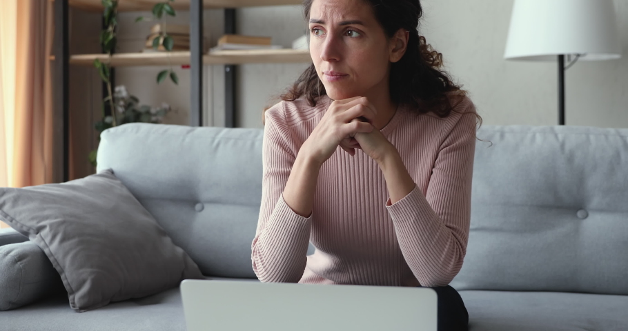Worried young adult woman looking at laptop feeling frustrated desperate reading bad negative online news sitting at home. Stressed upset female user using computer anxious about financial problems. Royalty-Free Stock Footage #1049471809