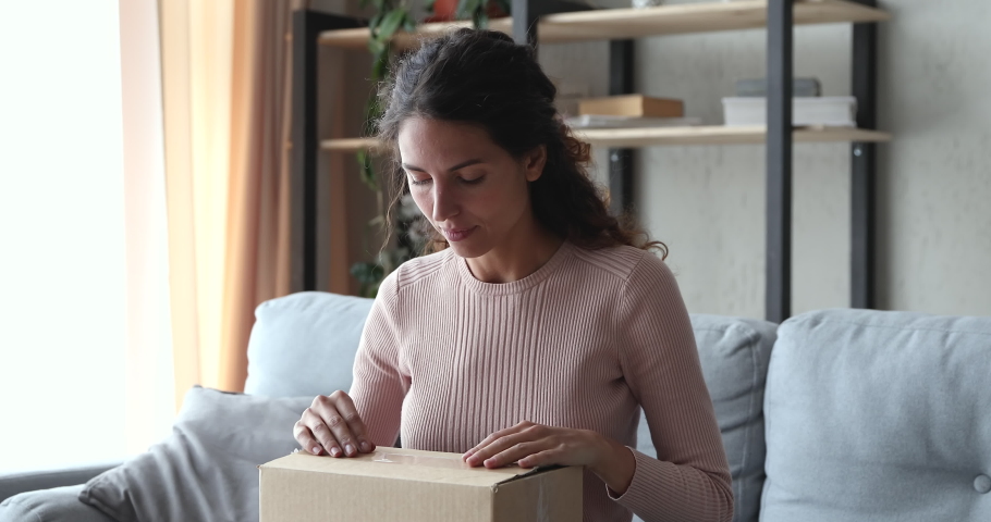 Frustrated upset young woman customer unpacking delivery at home. Angry dissatisfied shopper opening cardboard box feels bad surprise about damaged wrong bad parcel. Postal shipping problem concept Royalty-Free Stock Footage #1049471827