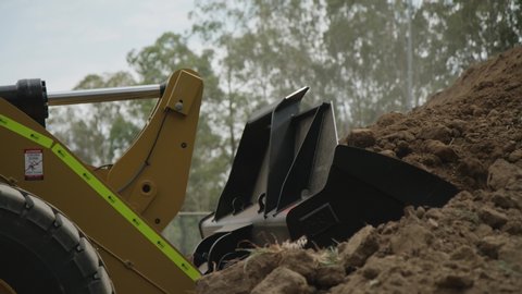 Agricultural video showing heavy earting machine picking up dirt