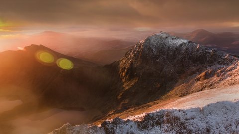 Snowdonia wales sunrise aerial timelapse with moving cloud and fog with snow covered mountains