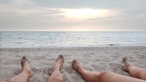 Couple legs on sand beach near blue sea water. 4K footage clip