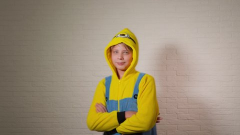 Chernihiv, Ukraine - January 16, 2020: Closeup view 4k video portrait of cute happy funny kid dressed in blue and yellow minion costume looking at camera happily.