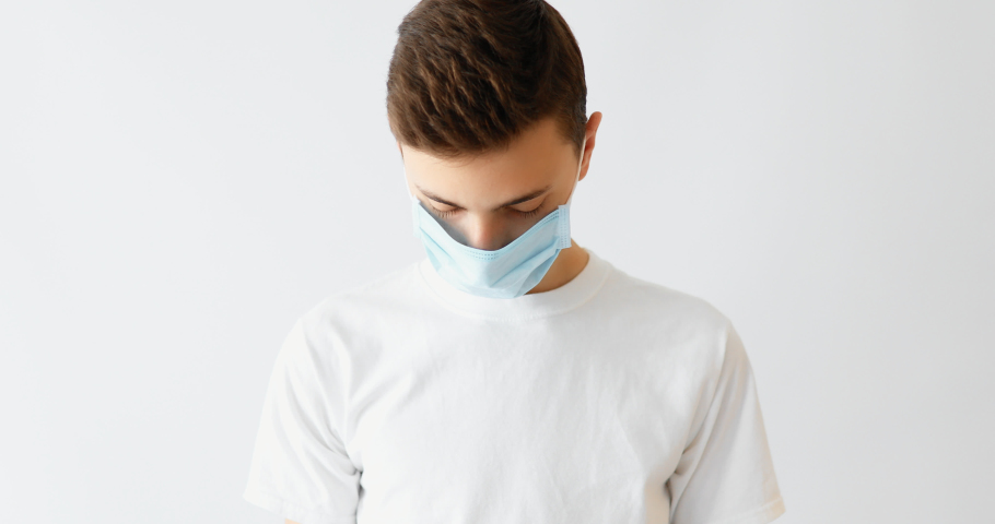 A young man wearing a medical mask to prevent infection, airborne respiratory disease, coronavirus isolated on a white background Royalty-Free Stock Footage #1049512435