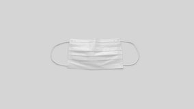 White protective medical mask on gray background with text. Banner of flu coronavirus Covid-19 and quarantine concept. Stock video.