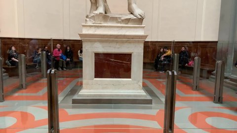 Florence, Italy -  January 25, 2020: People inside of famous Florence Accademia art museum gallery looking at view of David statue of Michelangelo