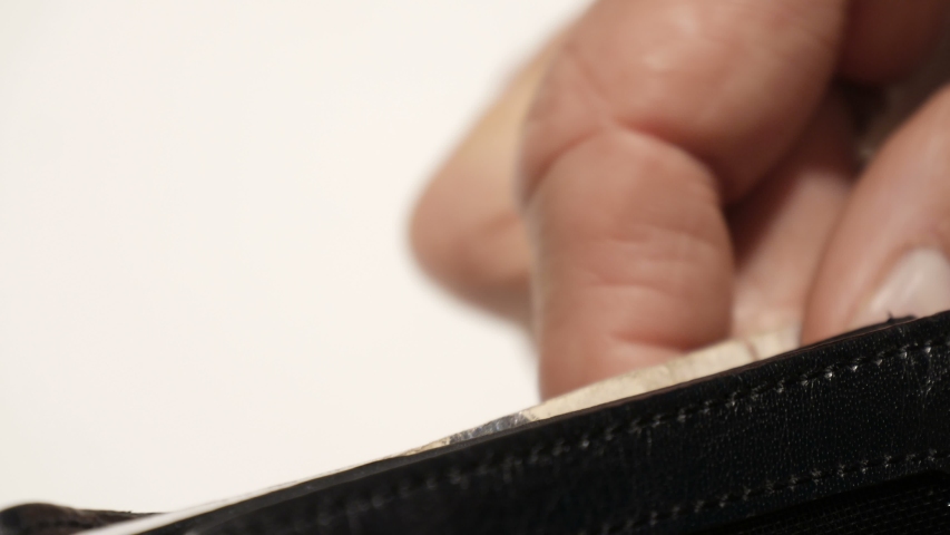 Close up narrow depth of field shot -  pale skin fingers & thumb partly extract British pound sterling notes from wallet to count them & then fully extract & place them out of wallet out of focus Royalty-Free Stock Footage #1049518921