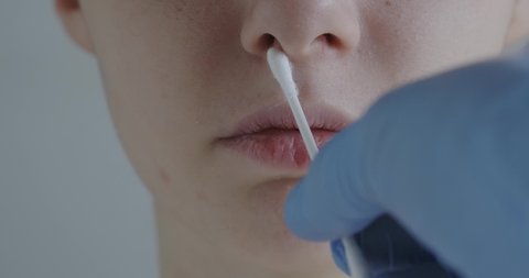 taking an analysis with a cotton swab in the nose