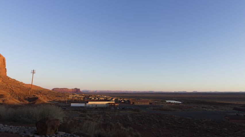A wide timelapse looking out east away from Monument Valley as the tourists start to wake up and vehicles move around the area.