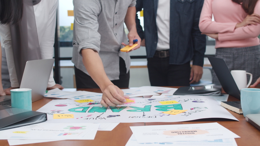 Close up hands of happy young Asian business people meeting brainstorming ideas about new paperwork project colleagues working together planning success strategy enjoy teamwork in office. Slow motion. Royalty-Free Stock Footage #1049522095