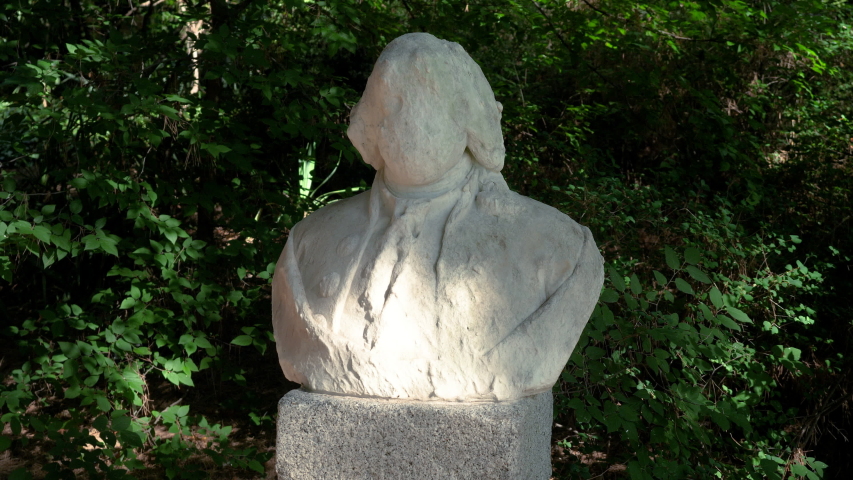 Statue of an unrecognizable historical figure in the green garden. Madrid. Spain. 4K