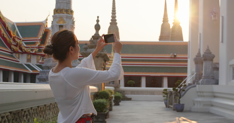 Woman take photo on cellphone in Thailand grand palace