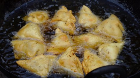 Making Of Delicious And Crunchy Samosas. Closeup Of Bubbles In Oil In Making Of Samosas. deep frying samosa