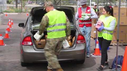 CIRCA 2020 - during the Covid-19 coronavirus epidemic outbreak, members of the armed forces hand out groceries at a food bank in Arizona.