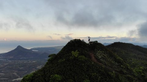 360 Degree Sweeping Drone Shot of Man Standing on Top of Mountain in Mauritius - Golden Hour Sunrise