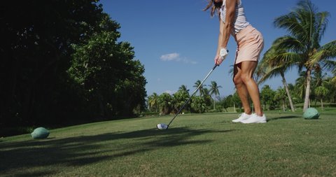 Athletic Woman driving golf ball