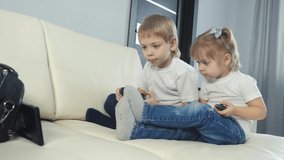 kids a boy and a girl are playing a portable set-top box in a TV controller. children play console in gamepads teamwork. happy family little boy and girl have fun online lifestyle games