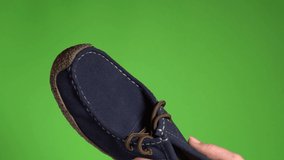 Closeup view 4k video of one single blue leather shoe with brown laces in hand of woman.