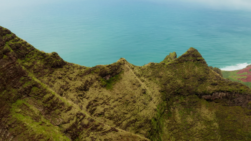 Stunning aerial view of Na Pali Coast State park. Unique Hawaii nature in its exotic beauty. Calm blue ocean and coastline view from over the pictorial volcanic coastal cliffs. 4K
