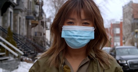 Woman puts on face mask to protect herself from the coronavirus outbreak and pandemic
