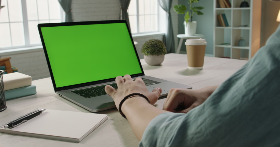 Close up shot of hands of freelancer working with chroma key green screen laptop, using trackpad scrolling through website - technology concept 4k video template Royalty-Free Stock Footage #1049560786