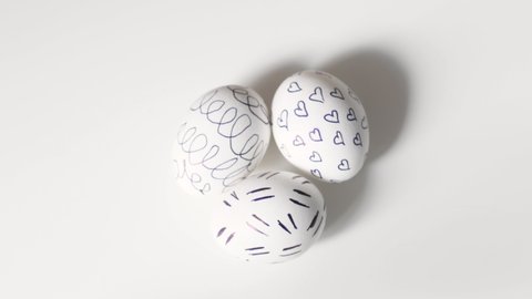 Unrecognizable woman removes painted Easter eggs from a white background. Easter eggs on a white background. the disappearance of eggs from a white background. three easter eggs on a white background