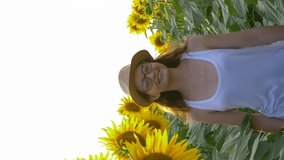 teenager girl walk around the field with sunflowers and enjoy the fresh air in slow motion, smartphone vertical screen
