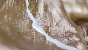 Metallic Gold and White Paint on Hands Macro - Macro shot of metallic gold and white paint dripping on hands. - Powered by Shutterstock - Get 15% off with code: PIKWIZARD15