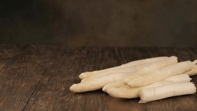 Woman breaks a stick of raw white asparagus. Healthy food.
