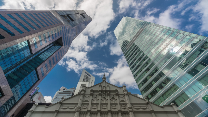 Looking up perspective of modern business skyscrapers glass and sky view landscape of commercial building in central city timelapse. Towers with reflections in Singapore