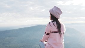 Video clip of Thai female tourists dressed in long-sleeved sweaters and wool hats Smiling happily watching the beauty of the sunrise on the top of the hill Pha Mor E Daeng National Park Sisaket.