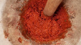 Slow-motion video of cooks pounding chili paste By using a mortar and pestle larger than normal to pound the chilli thoroughly Which is a way of life for rural villagers in Thailand.