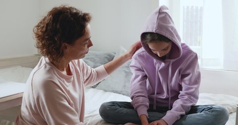 Caring single mother helping sensitive depressed teenage daughter after divorce concept. Affectionate worried young mom apologizing upset teen child girl giving love protection, psychological support.