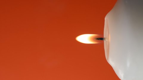 White candle flame on red background, coronavirus COVID-19 danger concept, vertical footage with copyspace