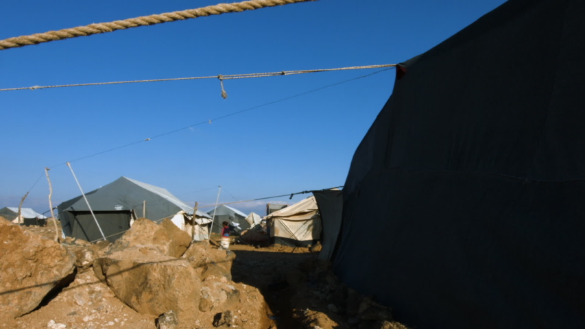 Long shot of some tents in a refugee camp.
