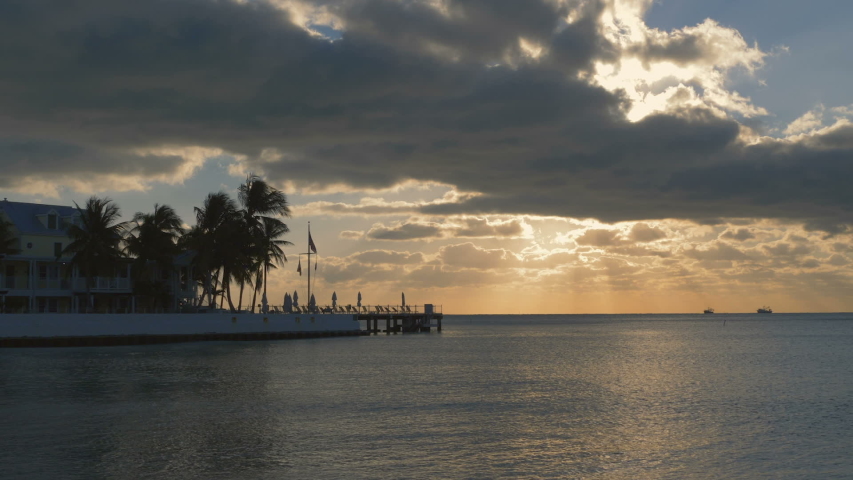 Beautiful sunrise on Key West, Florida, USA. With palms and resorts on background. Sunset over the sea at Key West, Florida. America flag waving in the wind, key west, Florida