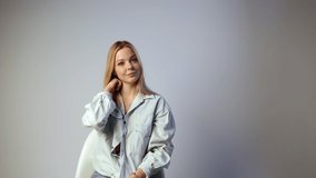 Closeup of young happy caucasian blonde woman looking at camera, talking, gesticulating on white background in studio. Smiling emotional girl telling something. Concept of storytelling, video blogging