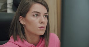 Business woman face looking at monitor in office. Close-up of girl thinking about mistakes in work. Portrait of female looking laptop at home. Over display camera shot. 4k video footage slow motion
