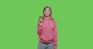 Focus pull of happy woman holding brown paper cup isolated over green screen background. Chroma key. 4k raw video footage slow motion