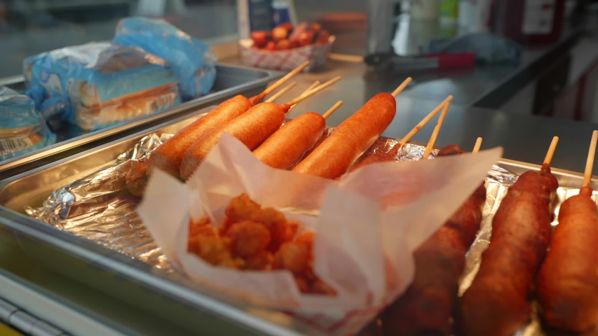 Corn dogs and unhealthy fried foods in the display case at a carnival or fair Royalty-Free Stock Footage #1049615632